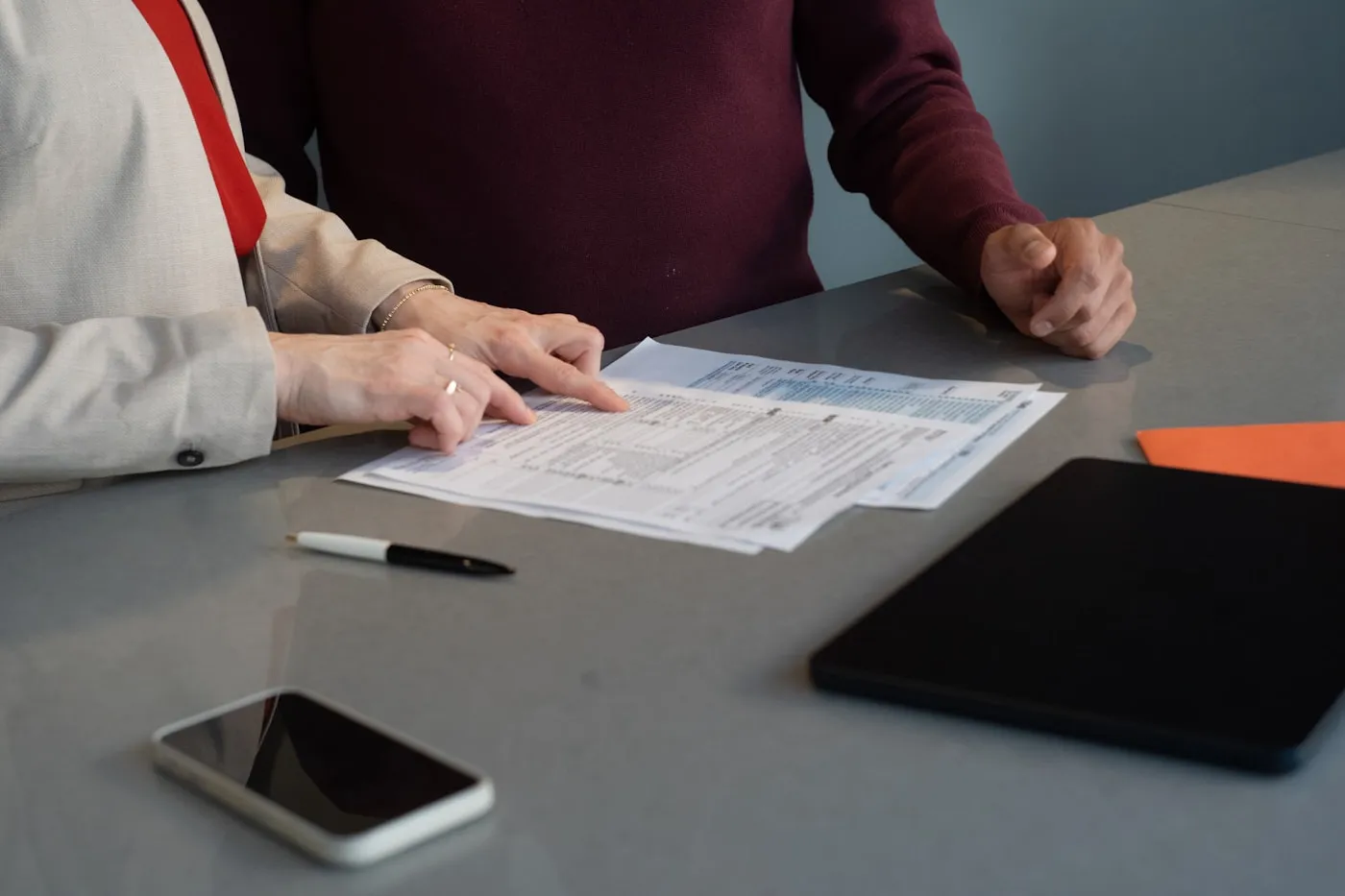 Dos personas revisando documentos sobre una mesa